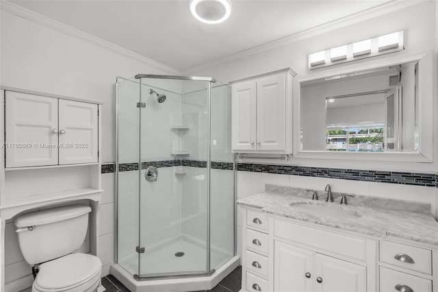 full bathroom featuring vanity, toilet, a stall shower, and crown molding