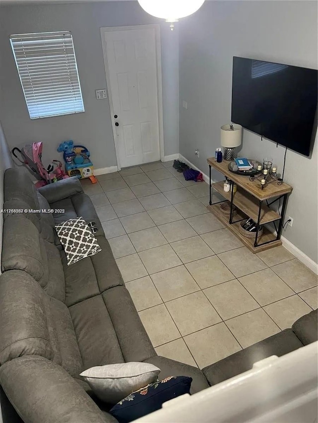 living area featuring light tile patterned floors and baseboards