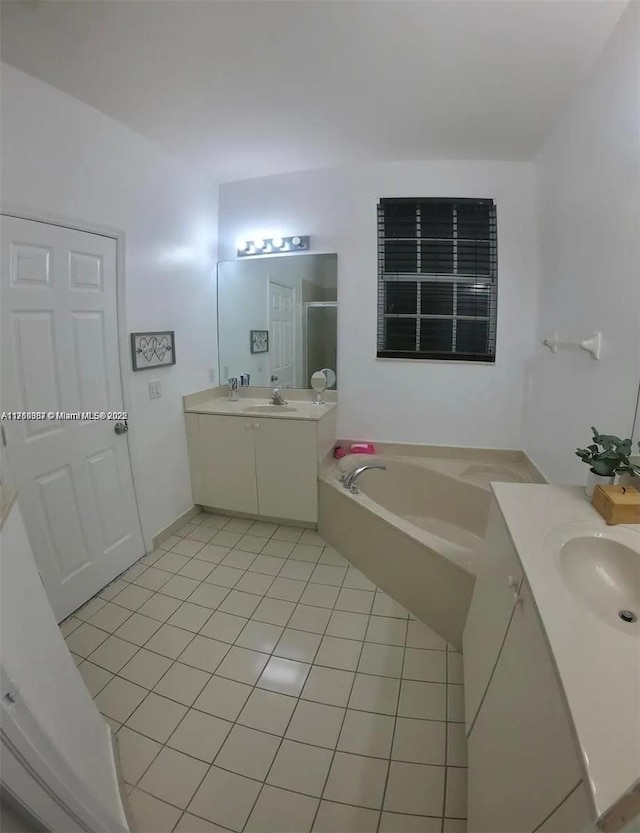 full bathroom featuring two vanities, a stall shower, a bath, tile patterned floors, and a sink