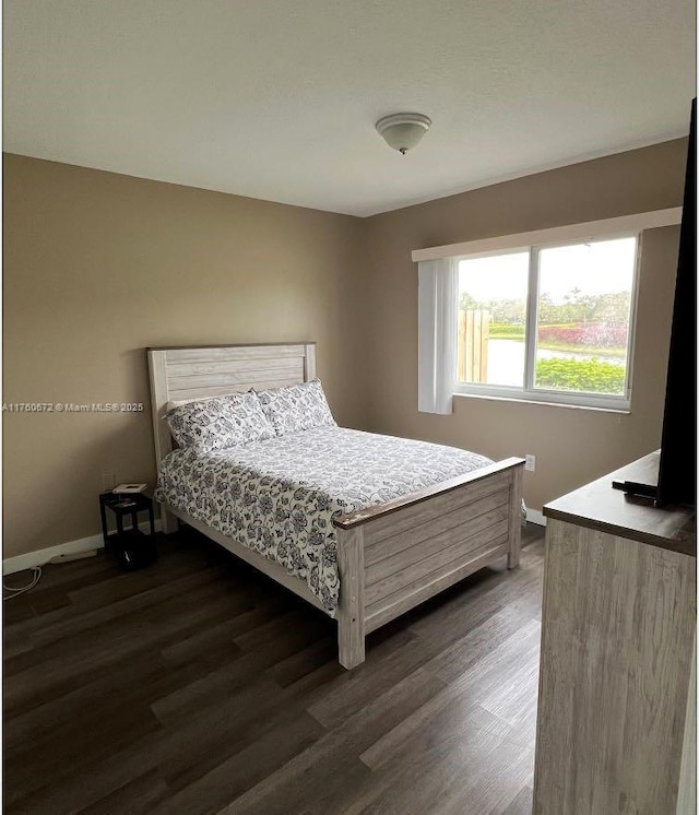 bedroom featuring dark wood-style floors and baseboards