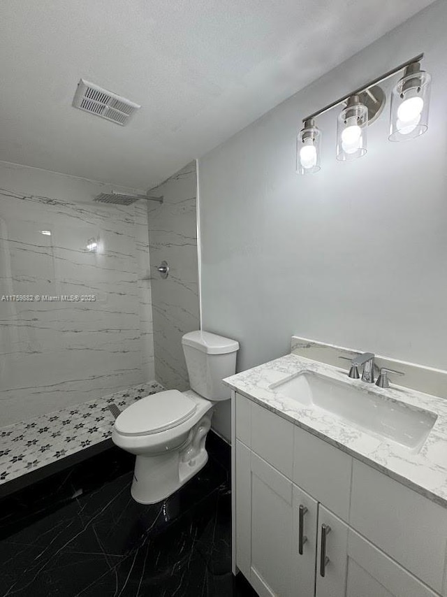 bathroom featuring a marble finish shower, visible vents, toilet, marble finish floor, and vanity