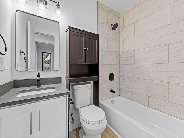 bathroom featuring vanity, washtub / shower combination, toilet, and wood finished floors