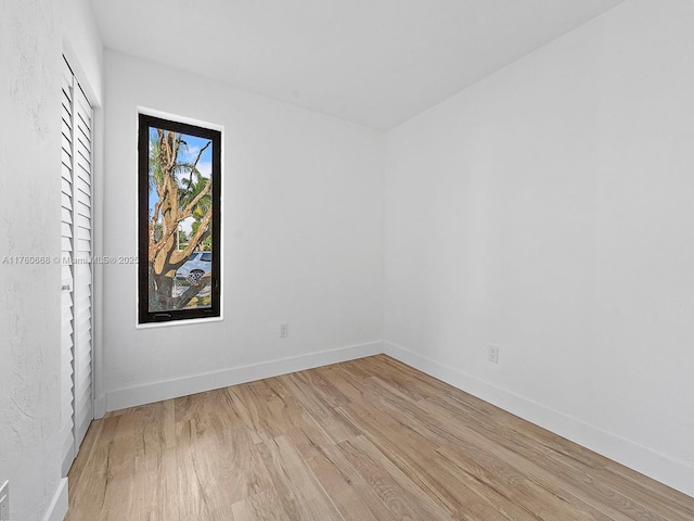 unfurnished room featuring baseboards and light wood-style floors