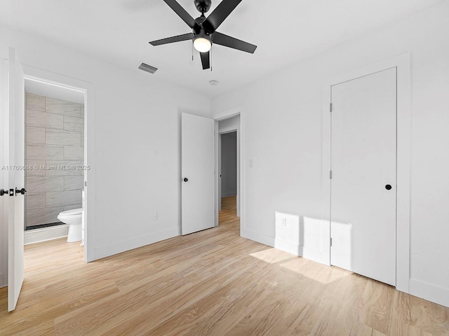 unfurnished bedroom with visible vents, wood finished floors, connected bathroom, baseboards, and ceiling fan