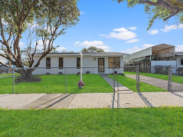 view of front of property featuring a fenced front yard, stucco siding, a front yard, and a gate