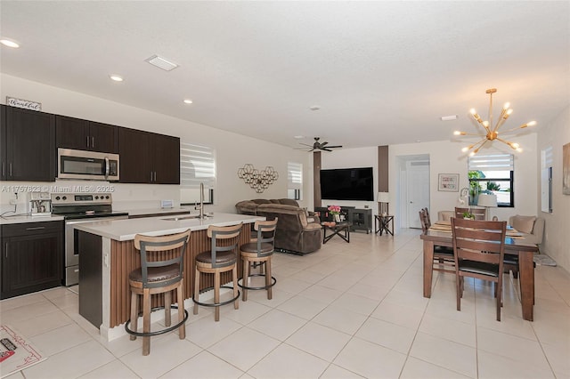 kitchen featuring visible vents, a sink, open floor plan, appliances with stainless steel finishes, and light countertops