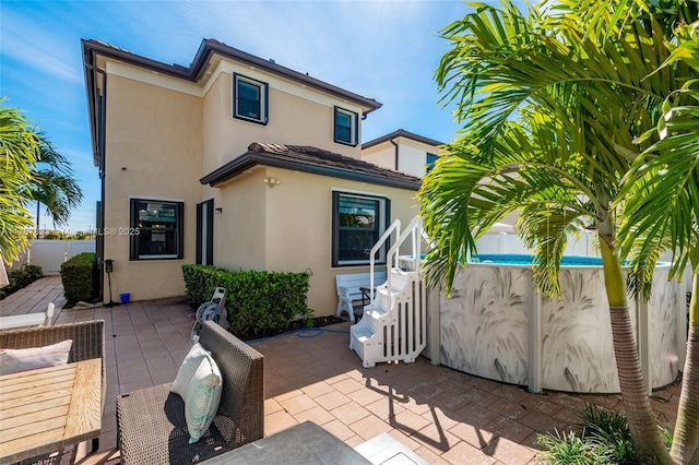 back of property featuring stucco siding, a patio, and fence