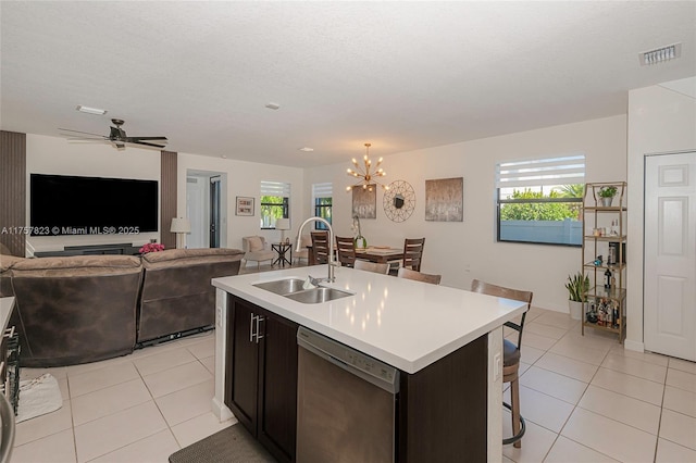 kitchen featuring a sink, stainless steel dishwasher, open floor plan, and light countertops