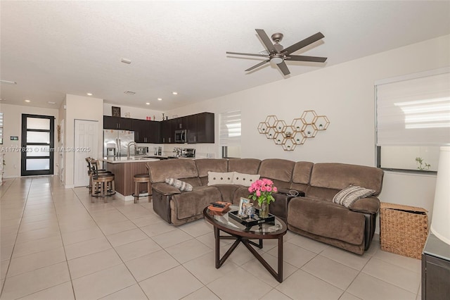 living room featuring light tile patterned floors, a textured ceiling, ceiling fan, and recessed lighting