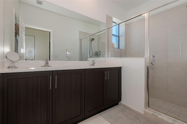 full bath with double vanity, visible vents, a stall shower, and a sink