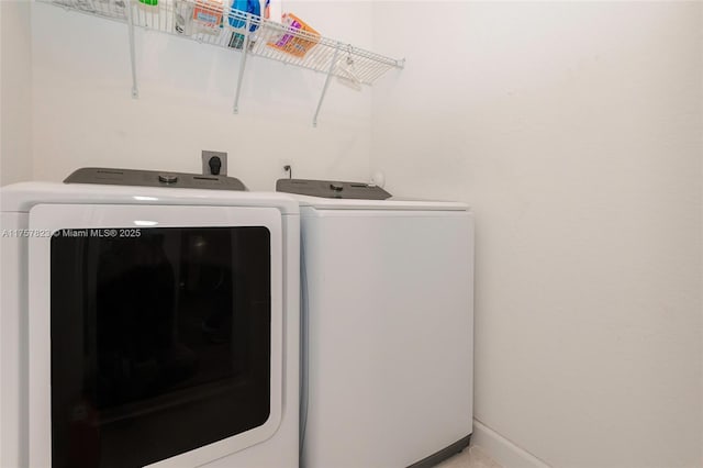 laundry room with laundry area, separate washer and dryer, and baseboards