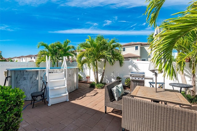 view of patio featuring a fenced in pool, a residential view, a fenced backyard, and grilling area