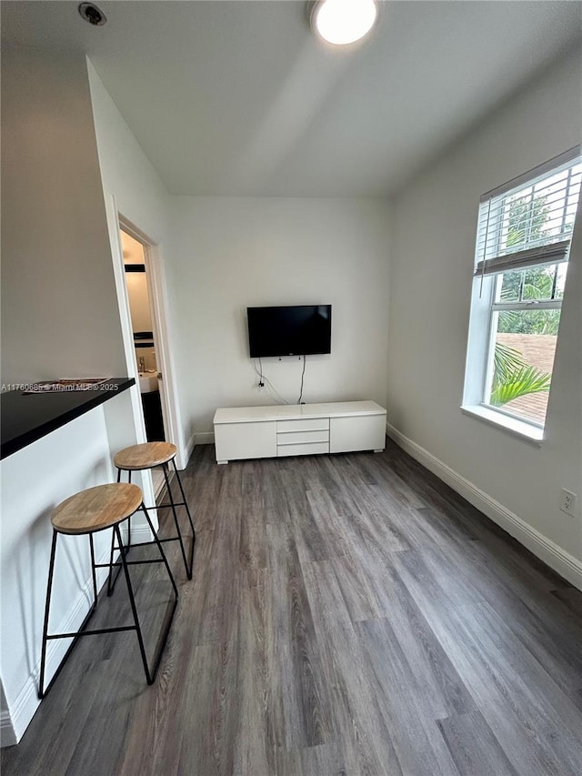 unfurnished living room with dark wood finished floors and baseboards