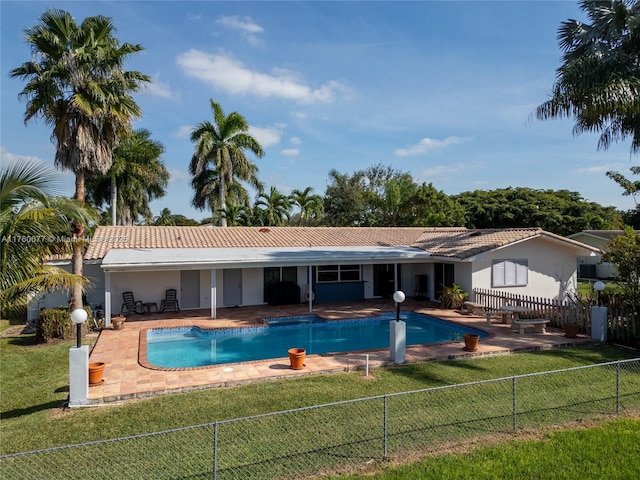 view of pool featuring a patio, a lawn, and fence