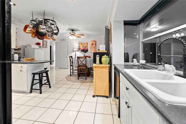 18200 SW 86th Ave, Palmetto Bay, FL 33157 - kitchen featuring a sink, white cabinets, light tile patterned floors, a kitchen breakfast bar, and ornamental molding