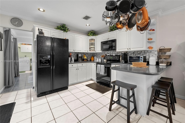 kitchen with visible vents, dark countertops, black appliances, and a peninsula