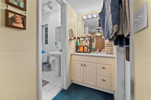 bathroom featuring tile patterned floors, a textured wall, and a sink