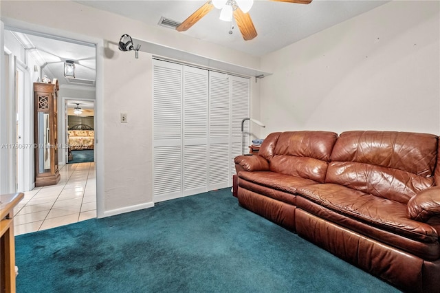 living area featuring light tile patterned floors, light colored carpet, crown molding, and ceiling fan