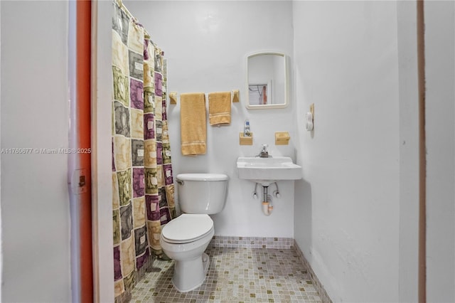 bathroom with tile patterned flooring, toilet, and a shower with curtain