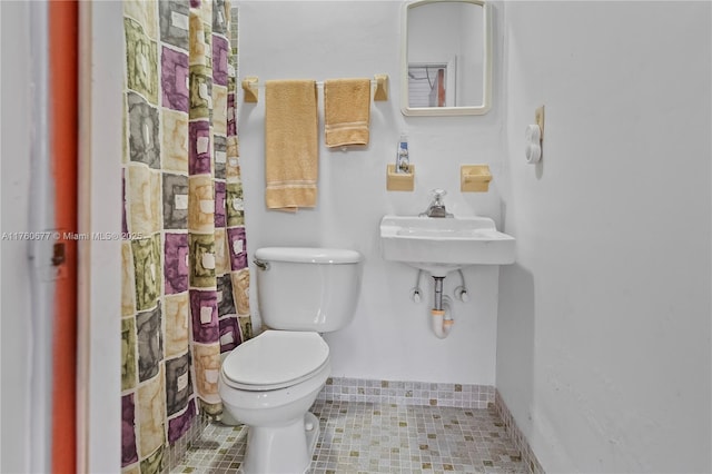 bathroom with baseboards and toilet