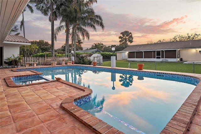 outdoor pool featuring a fenced backyard, a patio area, a yard, and a sunroom