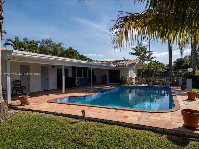 outdoor pool featuring a patio area and fence