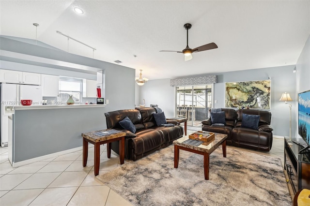 living area with light tile patterned floors, visible vents, ceiling fan, and vaulted ceiling