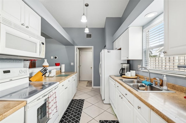 kitchen featuring a sink, white appliances, light tile patterned floors, and white cabinetry