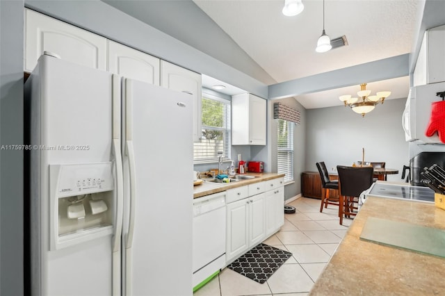 kitchen featuring vaulted ceiling, light tile patterned floors, white appliances, white cabinetry, and a sink