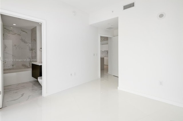 unfurnished room featuring baseboards, visible vents, and marble finish floor