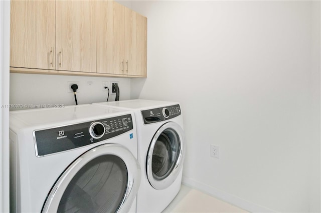 washroom featuring cabinet space, independent washer and dryer, and baseboards