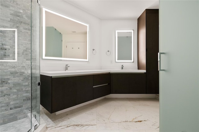 bathroom featuring a sink, marble finish floor, a stall shower, and double vanity