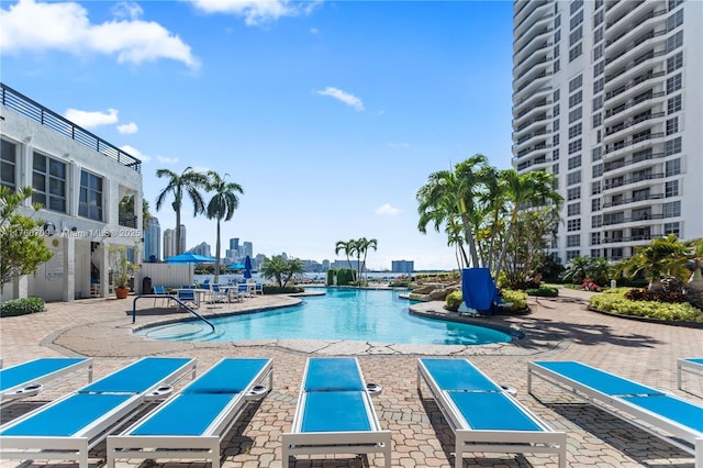 community pool featuring a view of city and a patio area