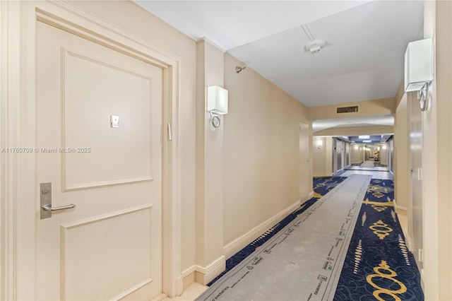 hallway featuring baseboards and visible vents