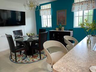 dining room featuring a notable chandelier, plenty of natural light, and baseboards