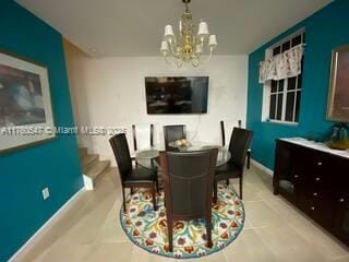 dining area with a chandelier, a fireplace, and baseboards