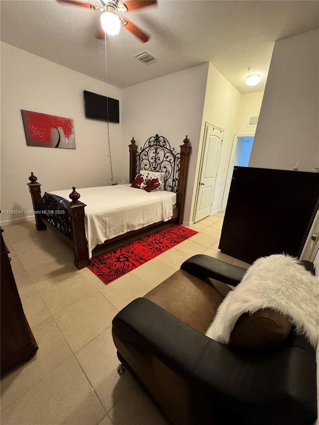 bedroom with visible vents, baseboards, a textured ceiling, and a ceiling fan