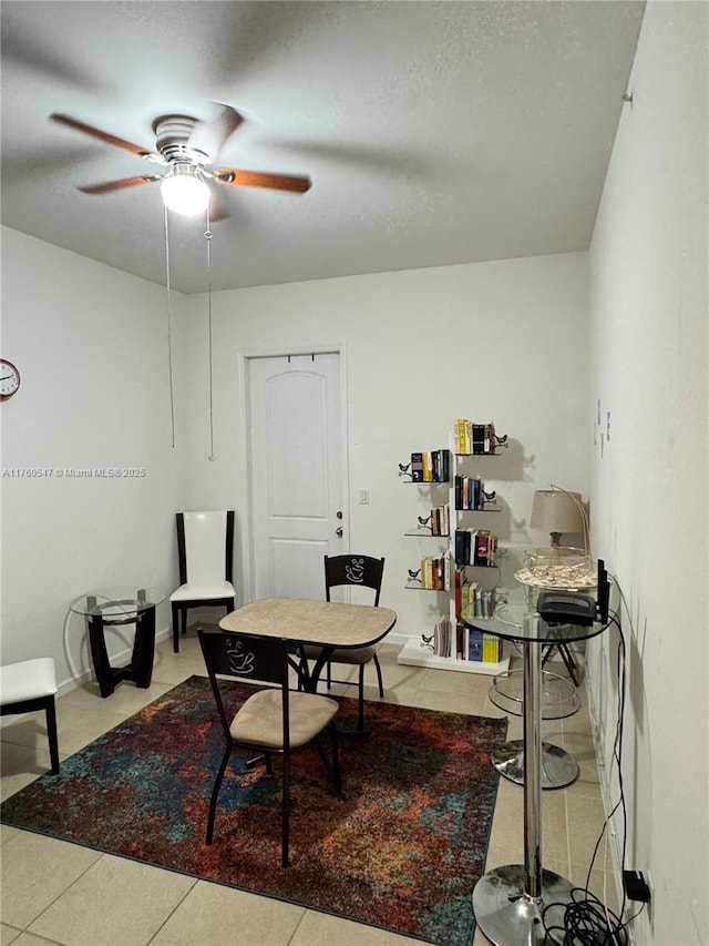 dining area featuring tile patterned floors, a textured ceiling, and ceiling fan