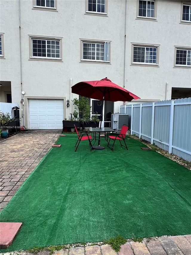 exterior space featuring an attached garage and fence