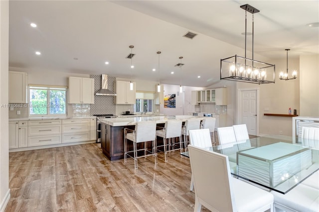 dining room featuring recessed lighting, visible vents, lofted ceiling, and light wood finished floors