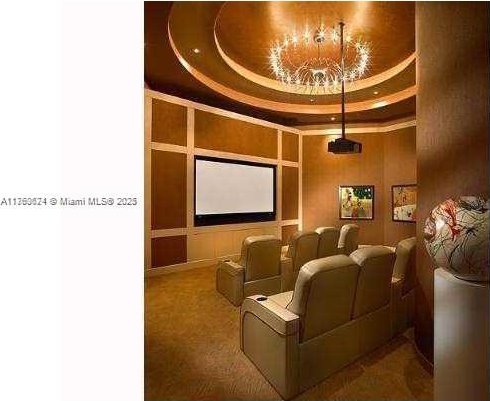 carpeted cinema room featuring a raised ceiling and a towering ceiling