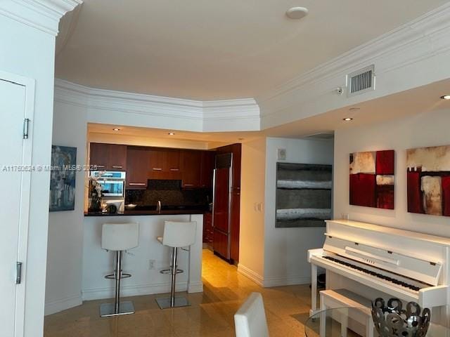 kitchen featuring visible vents, a peninsula, oven, built in refrigerator, and crown molding