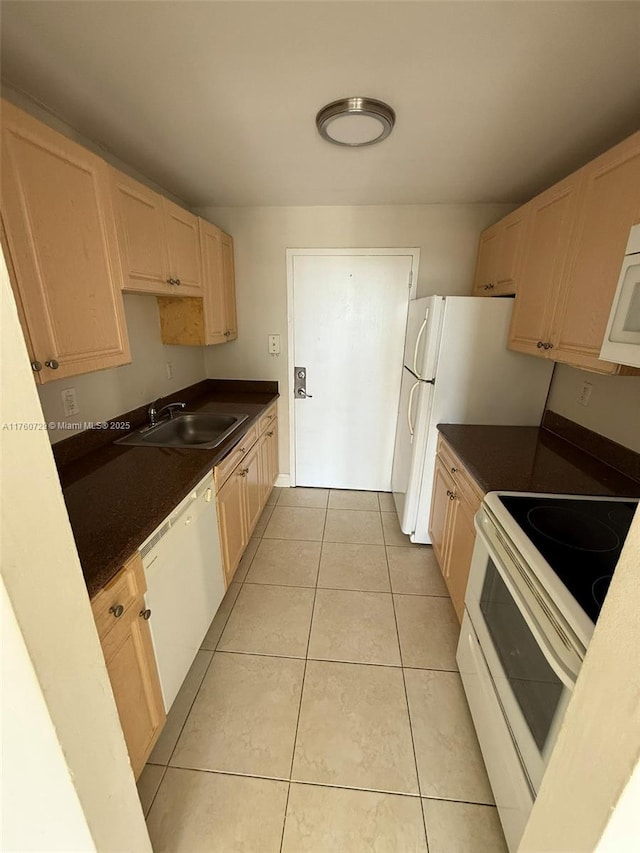 kitchen with white appliances, light tile patterned flooring, light brown cabinetry, a sink, and dark countertops