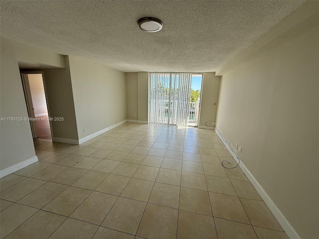 unfurnished room featuring baseboards, light tile patterned flooring, and floor to ceiling windows