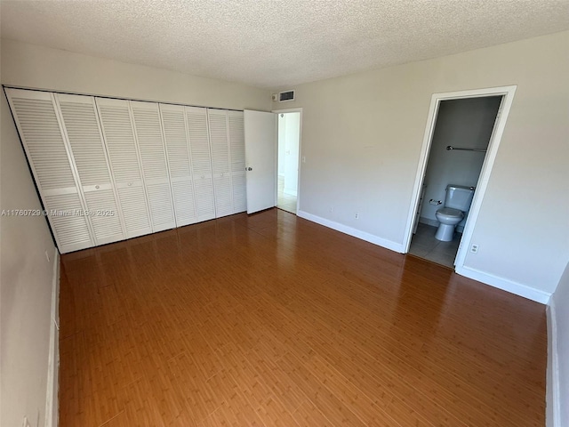 unfurnished bedroom with a closet, a textured ceiling, and baseboards