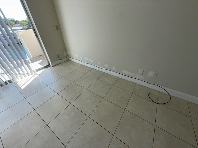 unfurnished room featuring light tile patterned floors and baseboards