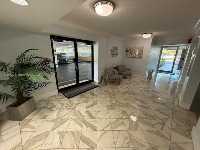 hallway featuring marble finish floor, a textured ceiling, crown molding, and baseboards