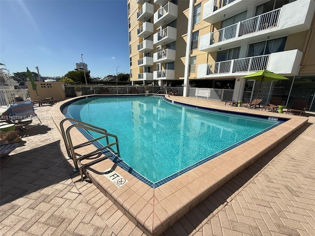 community pool featuring a patio and fence