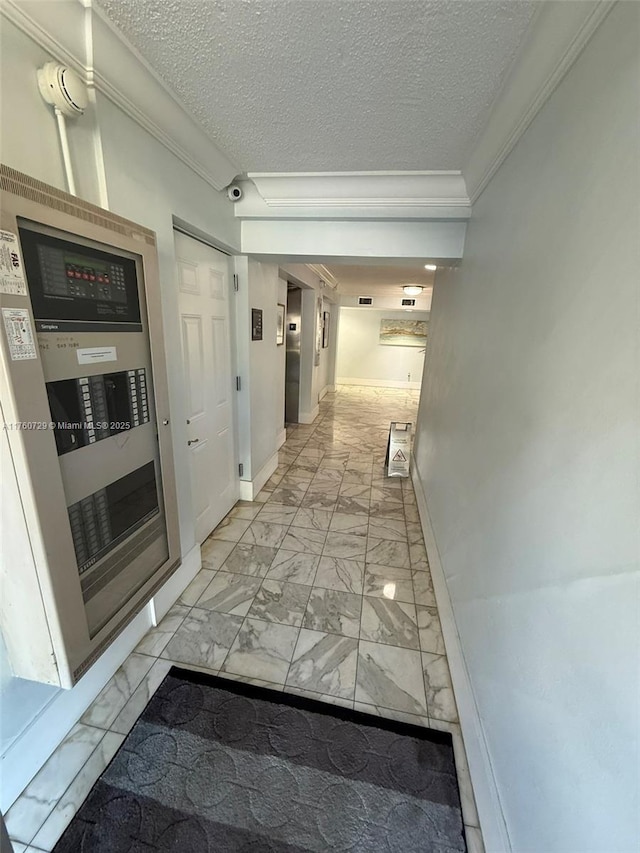 corridor with baseboards, a textured ceiling, marble finish floor, and crown molding