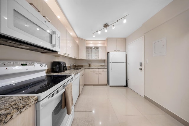 kitchen with light tile patterned flooring, track lighting, white appliances, and light stone counters